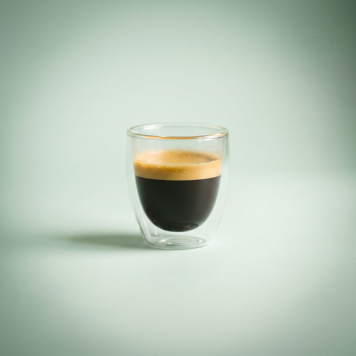 Double wall glass espresso cup with a fresh espresso and golden crema