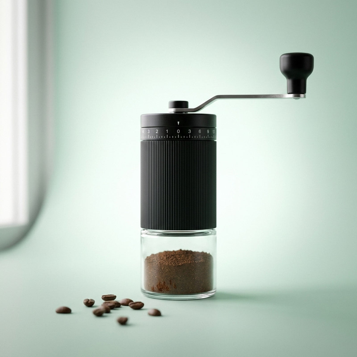 Manual coffee grinder with fresh espresso grounds and coffee beans