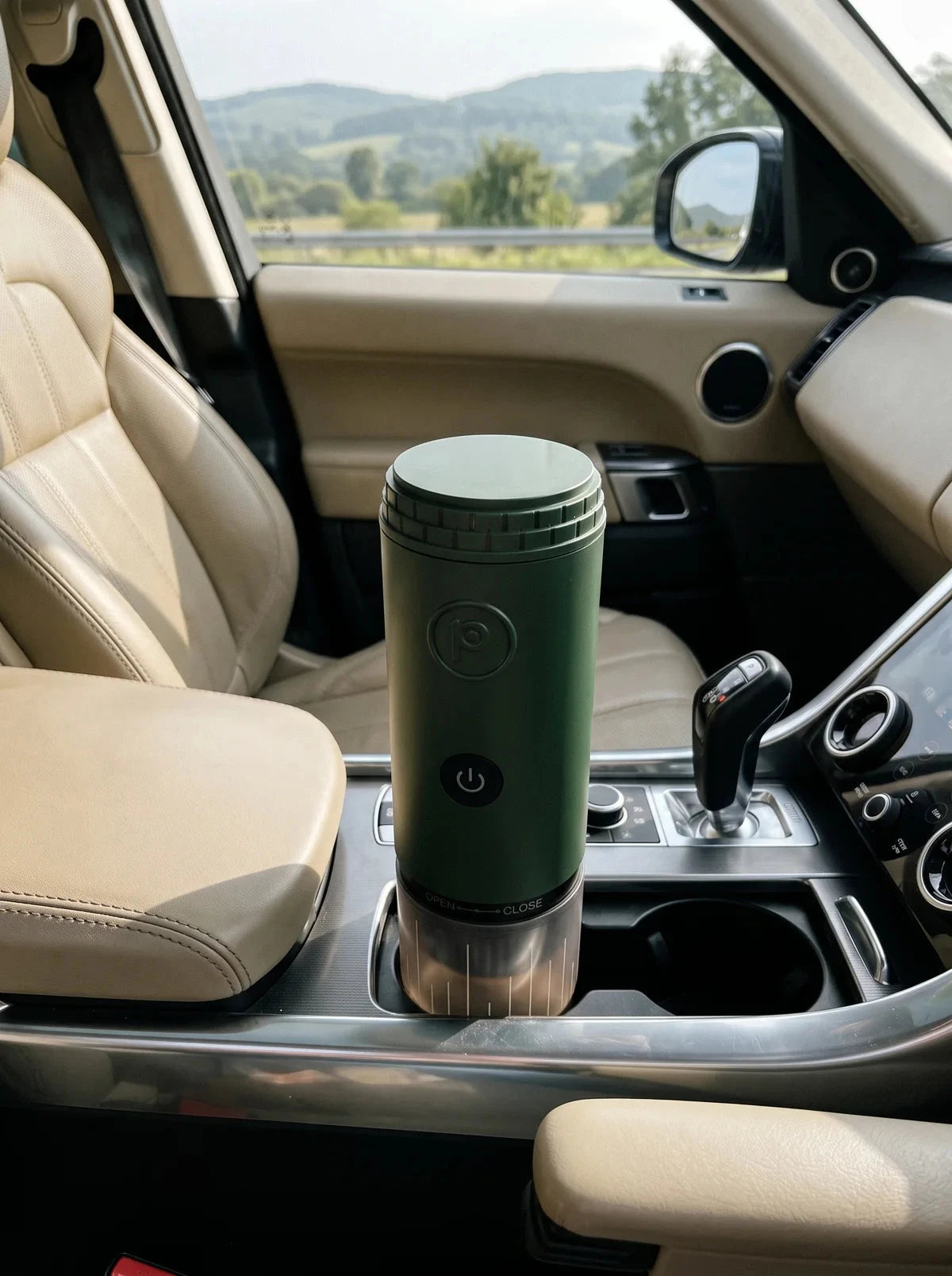 Forest green Origin portable espresso maker in a car cup holder