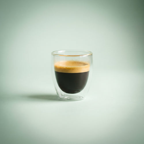 Double wall glass espresso cup with a fresh espresso and golden crema
