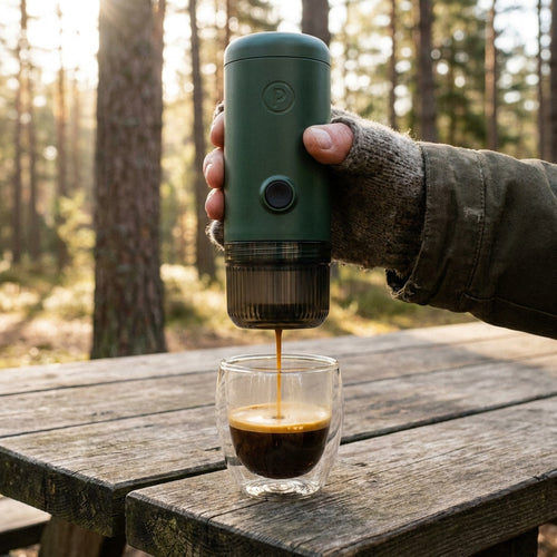 Origin portable espresso maker brewing espresso into the double wall glass outdoors