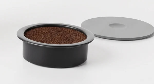 Grounds basket filled with coffee and its lid